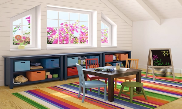 Bright kids playroom with a colorful rug, small activity table, toy storage cubbies, and a chalkboard.